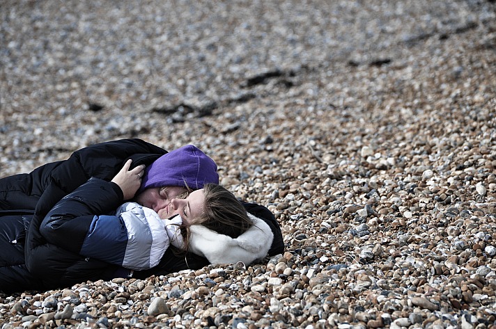 Just a guy and a girl sleeping on a pebble beach