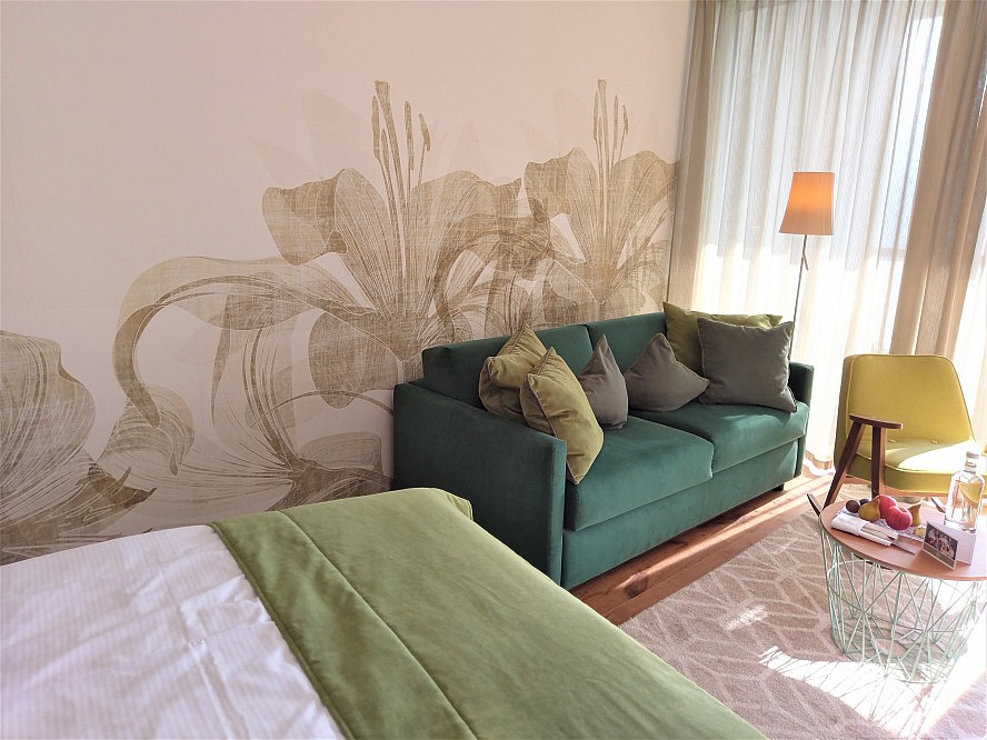 Hotel Hohenwart: Das elegant kombinierte Wohn-Schlafzimmer besticht vor allen Dingen mit seiner stilvoll-modernen Palette aus sanften Grüntönen