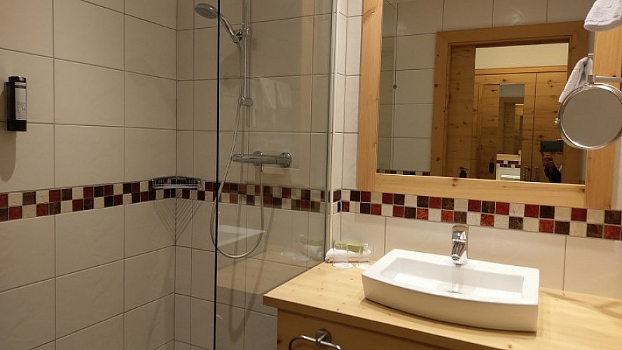 ALMGUT - Mountain Wellness Hotel: helles Badezimmer mit Doppelwaschbecken