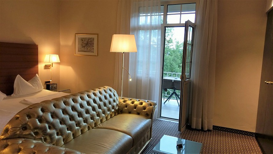 Hotel Meranerhof: Das goldene Sofa bildet den zentralen Mittelpunkt des großzügig geschnittenen Raumes.