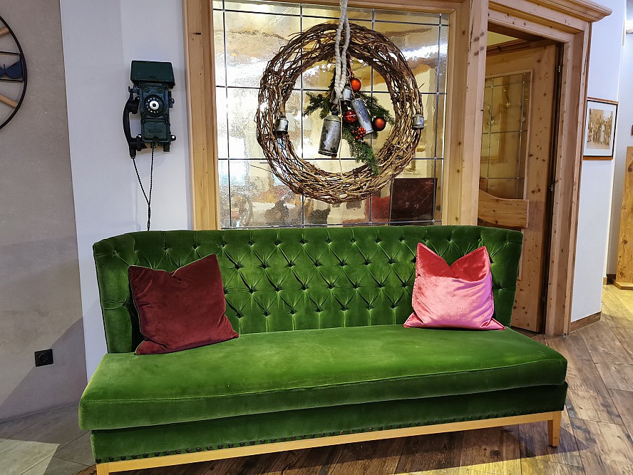 Sportresort Alpenblick: einladendes Sofa mit historischem Telefon im Eingangsbereich
