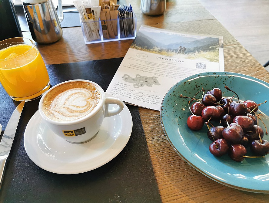 STROBLHOF Resort: Kirschen und frisch gepresster Orangensaft und dazu ein liebevoll verzierter Cappuccino zum Frühstück