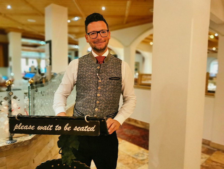 Hotel Alpenhof: der freundliche Servicemitarbeiter weist uns am ersten Abend den Weg zu unserem Tisch
