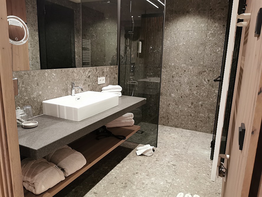 Gut Sonnberghof: Elegantes und modernes Badezimmer mit Regenwalddusche und separater Toilette